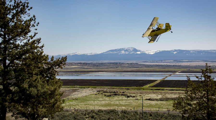 Agworld customer, Alturas Ranches, CA. Irrigation, biplane, mountains.
