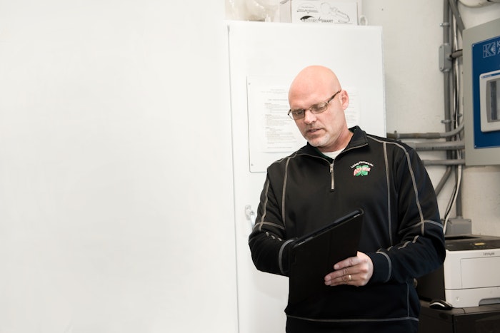 Agworld customer Luckey Farmers, Woodville, OH. Andrew Gladden using Agworld on iPad outside the office